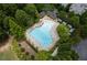 Aerial view of community pool surrounded by trees, cabanas and lounge chairs at 7235 Cordery Rd, Cumming, GA 30040