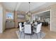 Elegant dining room with brick accent walls, a modern chandelier, and seating for six at 7235 Cordery Rd, Cumming, GA 30040