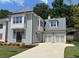 Charming two-story home featuring a metal roof, light blue siding, a two-car garage and a manicured lawn at 7235 Cordery Rd, Cumming, GA 30040