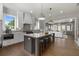 Bright, open kitchen featuring a large island with seating, hardwood floors and stainless steel appliances at 7235 Cordery Rd, Cumming, GA 30040