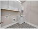Well-organized laundry room with upper cabinets and patterned tile floor at 7235 Cordery Rd, Cumming, GA 30040
