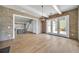 Open living room featuring wood floors and brick accent wall with view to the kitchen at 7235 Cordery Rd, Cumming, GA 30040