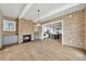 Bright living room features a brick accent wall, fireplace, and is open to the kitchen at 7235 Cordery Rd, Cumming, GA 30040