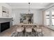 Dining room with fireplace, wood table, chandelier, walkout to patio, and view into kitchen; perfect for entertaining at 7275 Cordery Rd, Cumming, GA 30040