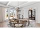 Bright dining room features a wood table with seating for six, modern chandelier, and walkout to a patio at 7275 Cordery Rd, Cumming, GA 30040