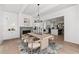 Dining room with fireplace, wood table, chandelier, walkout to patio, and view into kitchen; perfect for entertaining at 7275 Cordery Rd, Cumming, GA 30040