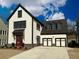 Beautiful two-story modern farmhouse featuring a red front door, two-car garage, and manicured landscaping at 7275 Cordery Rd, Cumming, GA 30040