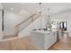 Modern kitchen island with bar seating and adjacent staircase at 7275 Cordery Rd, Cumming, GA 30040