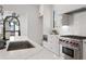 Bright kitchen boasts white cabinets, stainless steel appliances, and marble countertops at 7275 Cordery Rd, Cumming, GA 30040