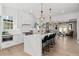 Stylish white kitchen featuring an island with marble countertops, stainless steel appliances, and modern pendant lighting at 7275 Cordery Rd, Cumming, GA 30040