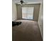 A large bedroom with neutral carpeting, a ceiling fan, and a window for natural light at 102 Governors Dr, Forest Park, GA 30297