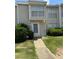Tan siding townhouse with a well-manicured lawn and clean walkway leading to the front door at 102 Governors Dr, Forest Park, GA 30297