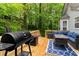 Wood back deck with outdoor seating and grill, surrounded by lush trees at 204 Queensbury Ct, Acworth, GA 30102
