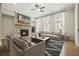 Cozy living room features a stone fireplace, a ceiling fan, and large windows for ample natural light at 2093 Callaway Nw Ct, Atlanta, GA 30318
