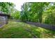 Large backyard view features a wooden fence and two-story home with a deck, surrounded by mature trees at 219 Brick Mill Dr, Canton, GA 30115