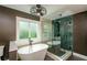 Bright bathroom featuring a luxurious freestanding tub and glass-enclosed shower with decorative tile at 219 Brick Mill Dr, Canton, GA 30115