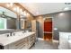 Modern bathroom boasts a double vanity, soaking tub, and decorative tile work; bathroom opens into the primary bedroom at 219 Brick Mill Dr, Canton, GA 30115