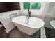 This bathroom has a freestanding tub with black finishes, a tiled niche, and glass shower enclosure at 219 Brick Mill Dr, Canton, GA 30115