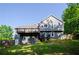 Rear exterior view of a two-story home with a deck overlooking a spacious lawn and verdant trees at 219 Brick Mill Dr, Canton, GA 30115