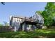 Backyard with a view of a two-story home with walkout basement and deck, surrounded by lush landscaping at 219 Brick Mill Dr, Canton, GA 30115