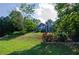 View of a two-story home with beautiful landscaping, including flowers and mature trees at 219 Brick Mill Dr, Canton, GA 30115