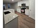 Modern kitchen featuring white cabinets, stainless steel appliances, granite countertops, and hardwood floors at 28 Samuel Nw Way, Cartersville, GA 30121
