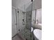 Modern bathroom shower with glass door, stone pebble floor, and gray tiled walls with a window at 28 Samuel Nw Way, Cartersville, GA 30121