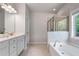Serene primary bathroom with a soaking tub, a separate glass-enclosed shower, and a double vanity; spa-like experience at 4830 Frontier Dr, Cumming, GA 30028