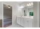 Bright bathroom features a double sink vanity, neutral paint, with the bedroom visible through the open door at 4830 Frontier Dr, Cumming, GA 30028