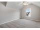 This bedroom offers neutral paint, carpet floors, a ceiling fan, and a single window that lets in ample light at 4830 Frontier Dr, Cumming, GA 30028