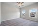 This bedroom boasts neutral walls, carpet floors, a ceiling fan, and two windows that fill the space with natural light at 4830 Frontier Dr, Cumming, GA 30028