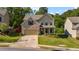 Two-story home with brick and vinyl siding, a well-manicured lawn and mature trees, and a two car garage at 4830 Frontier Dr, Cumming, GA 30028