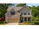 Charming two-story home featuring a mix of brick and siding, complemented by manicured landscaping at 4830 Frontier Dr, Cumming, GA 30028
