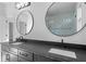 Modern bathroom featuring a double vanity with black countertops and round mirrors, offering a sleek and stylish design at 90 Cleveland Unit A Se St, Atlanta, GA 30316