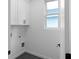 Clean laundry room featuring modern black hexagon tile floors and white cabinets with black hardware at 90 Cleveland Unit A Se St, Atlanta, GA 30316