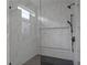 Modern shower with white marble-style tile, a frameless glass door, and a sleek black shower head at 90 Cleveland Unit A Se St, Atlanta, GA 30316