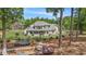 View of home exterior with backyard including a patio and trampoline set amongst mature trees at 2425 Wild Oak Ct, Stockbridge, GA 30281