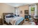 Cozy bedroom with a wooden bed frame, desk, and a scenic view of the outdoors at 2425 Wild Oak Ct, Stockbridge, GA 30281
