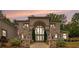 Stunning brick home with prominent lion statues, grand archway, and manicured landscaping at 2425 Wild Oak Ct, Stockbridge, GA 30281