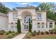 Stately home featuring a grand arched entryway, white brick, and well-maintained landscaping at 2425 Wild Oak Ct, Stockbridge, GA 30281