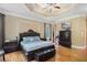 Spacious primary bedroom is furnished with hardwood floors, a trey ceiling, and traditional furnishings at 2425 Wild Oak Ct, Stockbridge, GA 30281