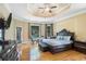 Large primary bedroom features a trey ceiling, hardwood floors, a sitting area, and backyard views at 2425 Wild Oak Ct, Stockbridge, GA 30281