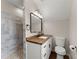 Bathroom with granite countertop, white cabinets, updated lighting, and stone shower at 2979 Overwood Sw Ln, Snellville, GA 30078