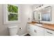 Modern bathroom with a wood countertop, white vanity and a large mirror at 2979 Overwood Sw Ln, Snellville, GA 30078