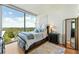 Bright bedroom with expansive windows, dark wood furniture, and scenic views at 3300 Windy Ridge Se Pkwy # 1401, Atlanta, GA 30339