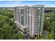 High-rise condominium building with glass exterior nestled among lush green trees shows a vibrant urban living at 3300 Windy Ridge Se Pkwy # 1401, Atlanta, GA 30339
