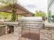 Outdoor kitchen with stainless steel grill, sink, and stone accents for outdoor cooking and entertaining at 3300 Windy Ridge Se Pkwy # 1401, Atlanta, GA 30339