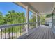 Balcony area with wood floors, white pillars and railings, and a view of the surrounding greenery at 632 Warren Ave, Scottdale, GA 30079