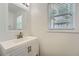 Clean bathroom features a white vanity and sink with a window providing natural light at 632 Warren Ave, Scottdale, GA 30079