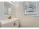 Bright half bathroom showcasing a modern vanity, updated fixtures, and a window with natural light at 632 Warren Ave, Scottdale, GA 30079